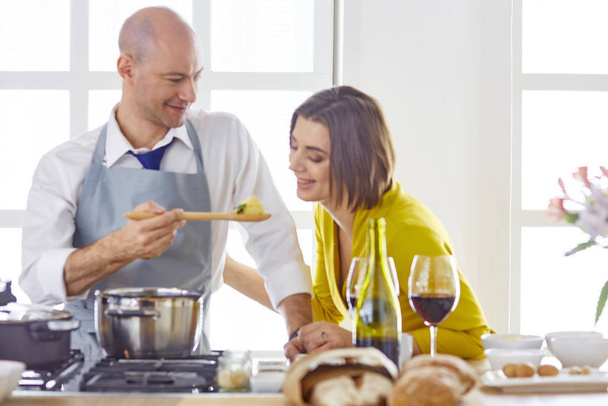 Lächelndes junges Paar kocht Essen in der Küche - Foto, Bild