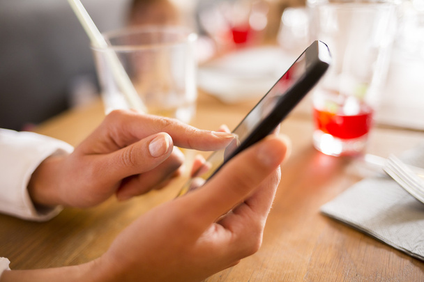 Close up of hands woman using her cell phone in restaurant - Photo, Image