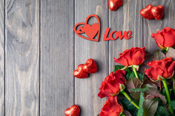 Romantyczny Saint Valentine drewniane tło karty z bukietem pięknych czerwonych róż i Love liternictwo - Zdjęcie, obraz