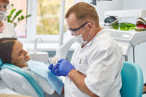 歯医者は美しい少女患者の歯を治療する。歯医者の受付の女の子。歯医者は歯を治療する - 写真・画像