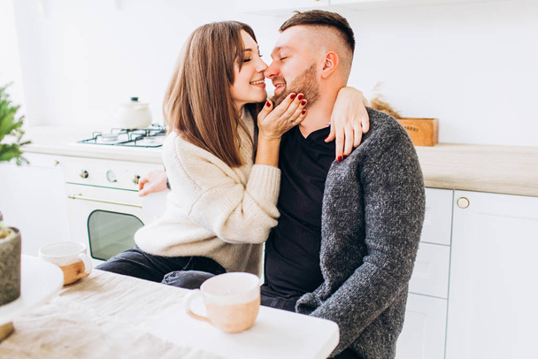 Loving couple kisses in the kitchen. Couple at the dinner table. - Fotografie, Obrázek
