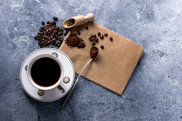 šálek kávy a kávová zrna na šedém pozadí s prostorem pro váš text - Fotografie, Obrázek