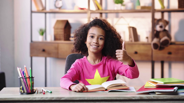 glimlachen Afrikaans amerikaans kind lezen boek en tonen duim omhoog - Video