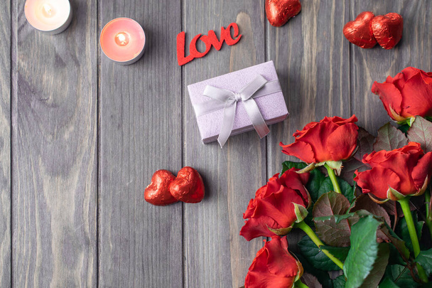 romantische Valentinstag Holzhintergrundkarte mit Strauß schöner roter Rosen und Geschenk - Foto, Bild