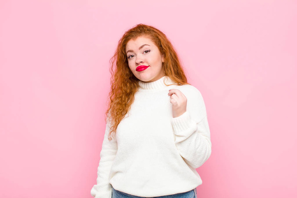 young red head woman looking arrogant, successful, positive and proud, pointing to self against pink wall - Fotografie, Obrázek