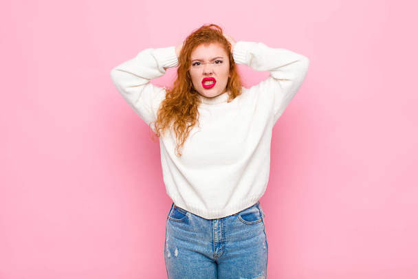 young red head woman feeling frustrated and annoyed, sick and tired of failure, fed-up with dull, boring tasks against pink wall - Foto, Imagem