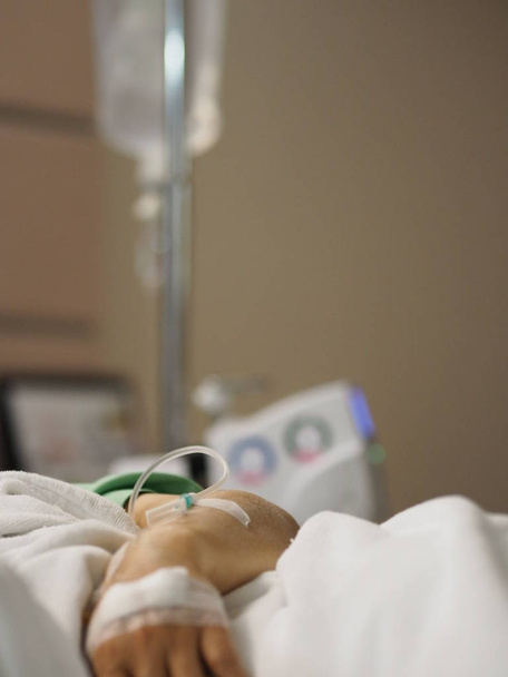Patiënten slapen op het bed afdeling set Iv zoutoplossing in vrouwelijke hand in het ziekenhuis - Foto, afbeelding