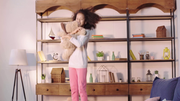 heureux enfant afro-américain sautant avec ours en peluche sur le lit
 - Séquence, vidéo