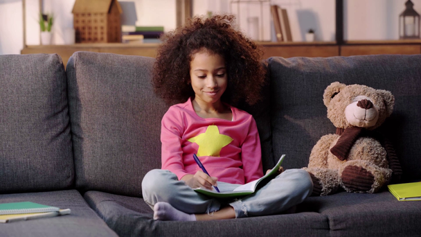 afro-amerikai gyerek házi feladatot csinál a kanapén - Felvétel, videó