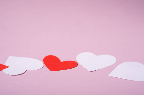 Červený a bílý ručně vyrobený papír srdce valentinky na růžovém pozadí, úhel pohledu, selektivní zaměření - Fotografie, Obrázek