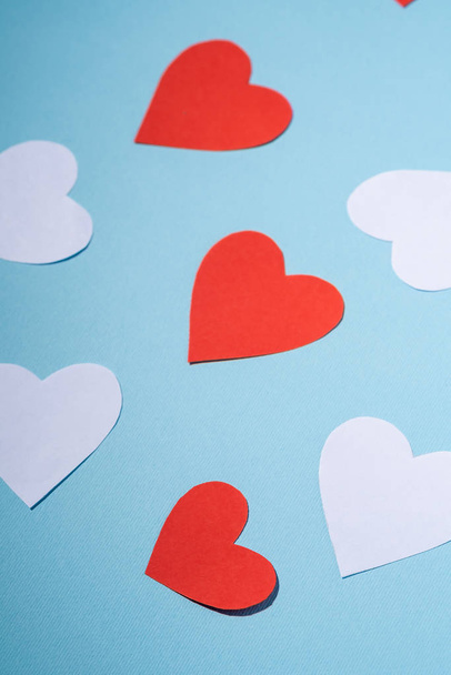 Red and white handmade paper hearts valentines on blue background, angle view, selective focus - Photo, Image