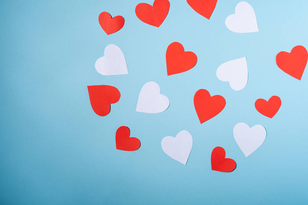 Červené a bílé ručně vyráběné papírové srdce valentinky na modrém pozadí, horní pohled - Fotografie, Obrázek