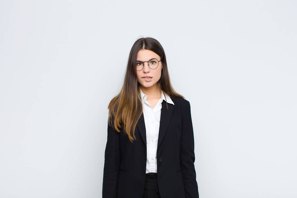young businesswoman feeling clueless, confused and uncertain about which option to pick, trying to solve the problem against white wall - Fotoğraf, Görsel
