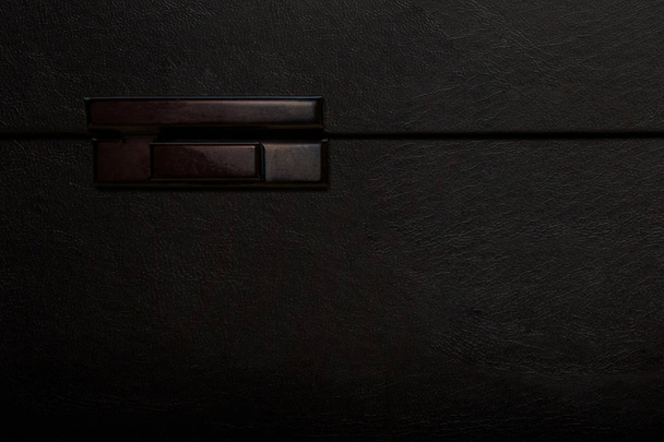 Передняя сторона большого черного ящика с защелкой. Close up flat lay view wi
 - Фото, изображение