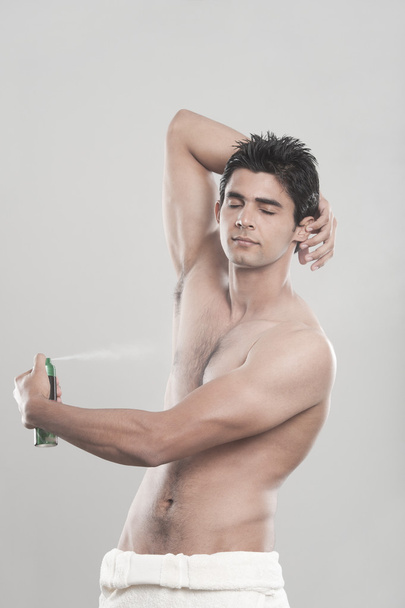 Man applying deodorant over his body - Foto, Imagem