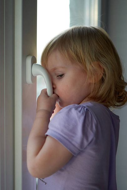 A little girl standing in front of a window - Fotoğraf, Görsel