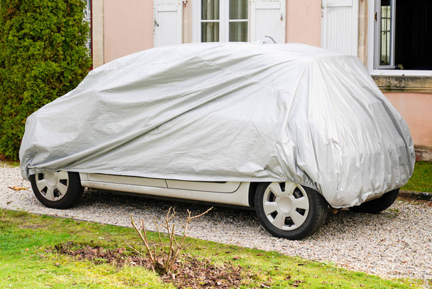 coche bajo cubierta de color plata exterior en invierno
 - Foto, imagen