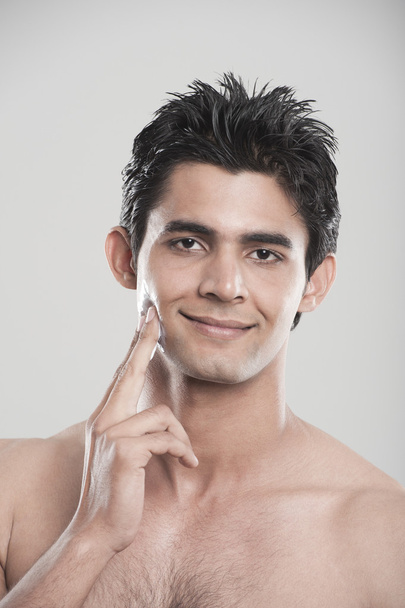 Man applying moisturizer on his face - Photo, Image