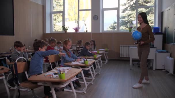 Μαθητής σηκώνει το χέρι κατά τη διάρκεια του μαθήματος γεωγραφίας - Πλάνα, βίντεο