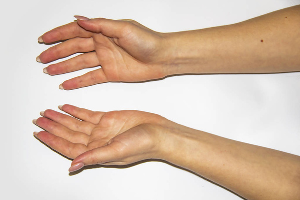A női kezek kompozíciója, ami valami könnyű hátteret akart tartani. A női kezek próbálnak elkapni valamit. Fogantatás női kezekkel. - Fotó, kép