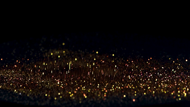 Prellen von Goldpartikeln auf schwarzem Hintergrund, das Konzept von Rhythmus oder Musik - Filmmaterial, Video