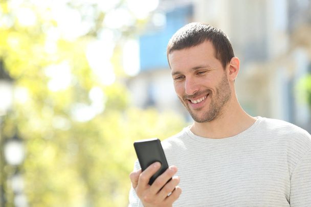 Happy adult man checking text in a mobile phone - Foto, Imagem