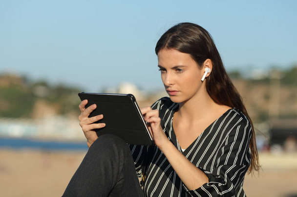 Súlyos női e-learning tablettával és fülhallgatóval - Fotó, kép