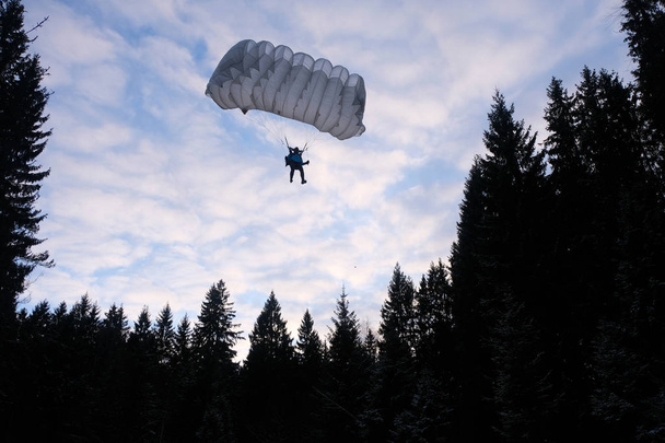 Pontos ejtőernyőzés. Egy ejtőernyős fog leszállni az erdőben.. - Fotó, kép