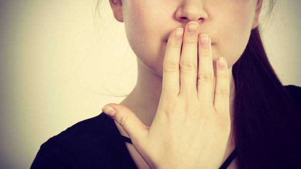 Woman covering her mouth with hand - Foto, imagen
