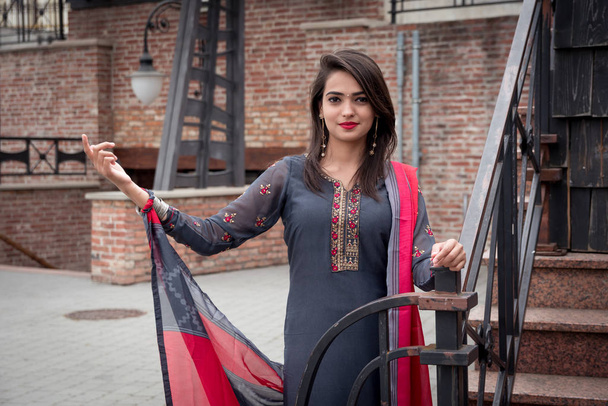 An Indian girl stands on the street of the city. Girl in traditional Indian clothing, salwar kameez. - Photo, Image