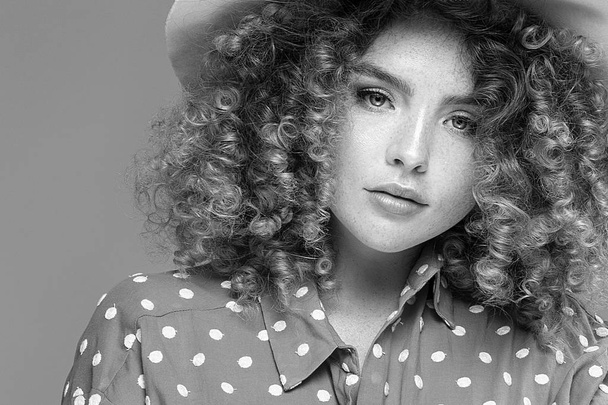Woman with curly hairstyle and natural freckles. - Фото, изображение