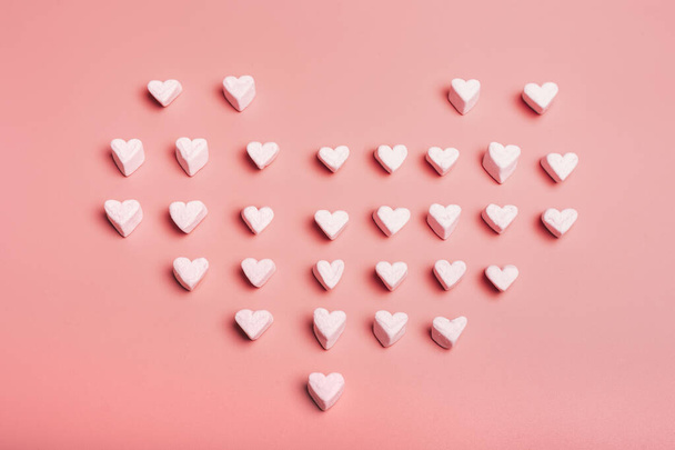 Serce wykonane z chmur cukierków w kształcie serca na różowym tle. Walentynki. - Zdjęcie, obraz