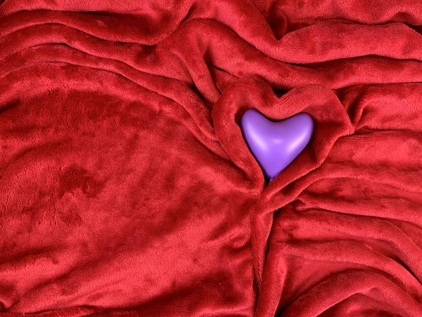 Kolorowe serce na miękkiej tkaninie. Serce na czerwonym nakryciu. Koncepcja: Walentynki, miłość - Zdjęcie, obraz