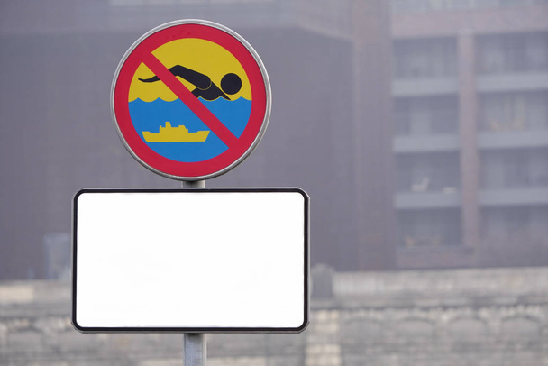 przestrzeń do kopiowania, biała tablica informacyjna pod znakiem zakazującym pływania w zbiorniku miejskim. Bezpieczeństwo wody, znaki zakazu, infrastruktura miejska - Zdjęcie, obraz