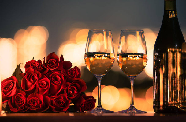 Romantic candlelight dinner with red roses and bokeh lights.  Concept for Valentine's Day or date. - Photo, image