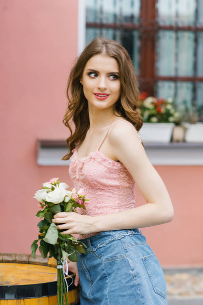beautiful smiling girl with a bouquet of roses in her hands - Foto, Bild