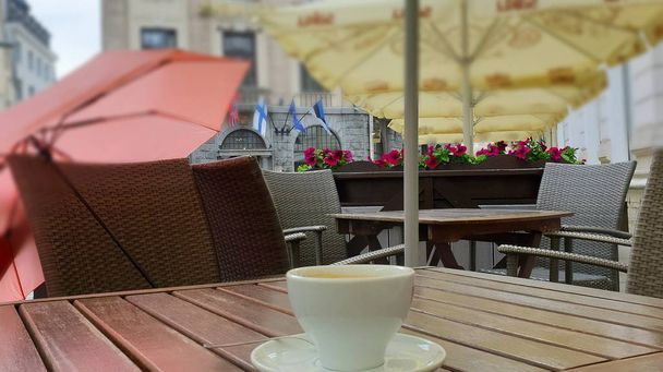  street cafe το βράδυ Κύπελλο του καφέ στο τραπέζι στο δρόμο καφέ Ταλίν παλιά πόλη θολή πανοραμική φόντο ταξίδια διακοπών στην Ευρώπη Εσθονία  - Φωτογραφία, εικόνα