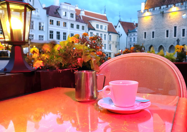 Stadt Straßencafé, Tasse Kaffee auf dem Tisch, Abend Tallinn Altstadt verschwommenes Panorama, Lebensstil urbanes Licht verschwimmen, Reisen Urlaub in Europa Estland bunt  - Foto, Bild
