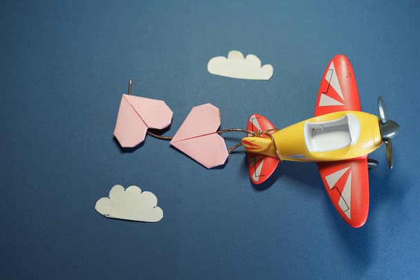 Αεροπλάνο παιχνίδι με origami χαρτί ροζ καρδιές. - Φωτογραφία, εικόνα