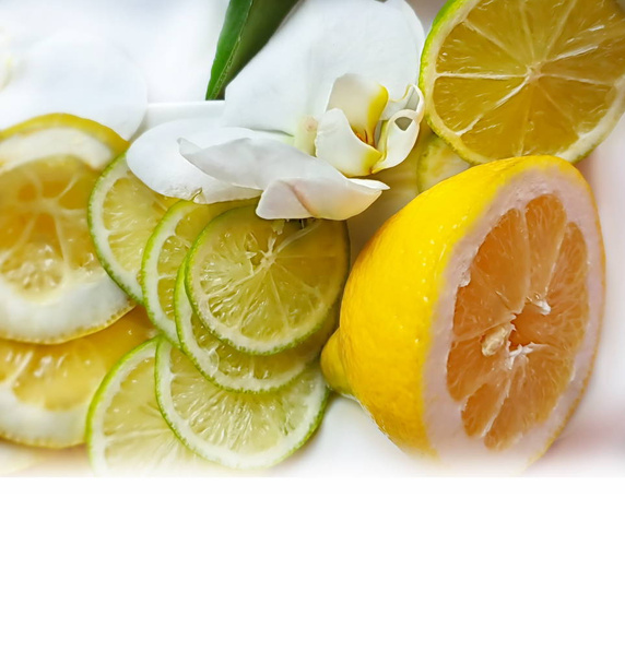 Лимонные ломтики цитрусовых и лайма сочные ломтики фруктов на голубом фоне плиты натюрморт, здоровая пища с цветами орхидей, зеленый и желтый дизайн украшения пищи тропические
  - Фото, изображение