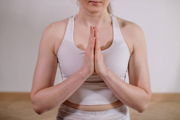 Νεαρή σπορ ελκυστική γυναίκα που κάνει γιόγκα, διαλογίζεται σε στάση γιόγκα, γυμνάζεται, φοράει αθλητικά ρούχα, εσωτερική ολόσωμη, light yoga Studio - Φωτογραφία, εικόνα