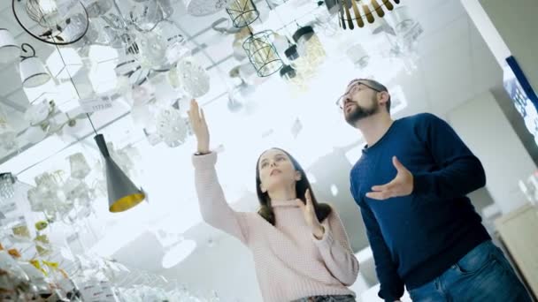 Mladý pár si vybere lampu v obchodě s elektrickým zbožím. - Záběry, video