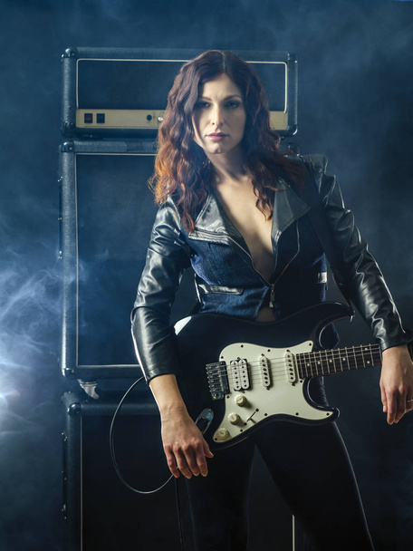 Beautiful woman with red hair holding electric guitar - Foto, Bild