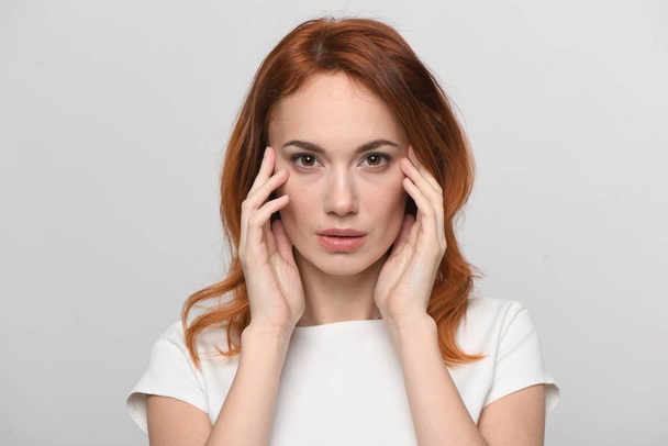red-haired woman with hands near face - Fotoğraf, Görsel