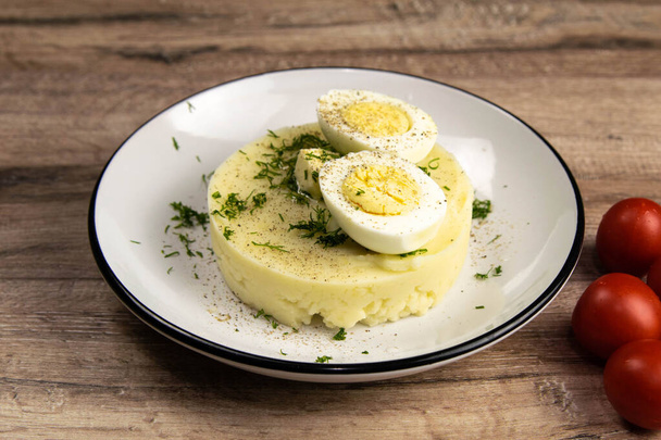 Jedzenie ziemniaczane. Składniki puree ziemniaczanego - jaja, mleko, masło i ziemniaki na drewnianym tle - Zdjęcie, obraz