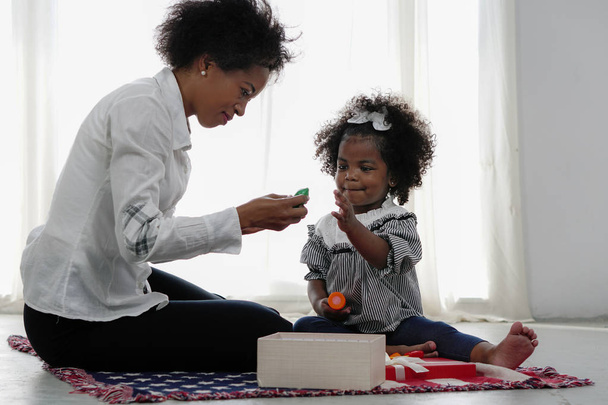 africano americano madre y chica niño jugando juguete juntos
 - Foto, Imagen