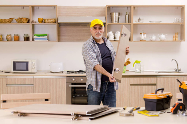 Entrepreneur âgé réparateur travaillant dans la cuisine - Photo, image