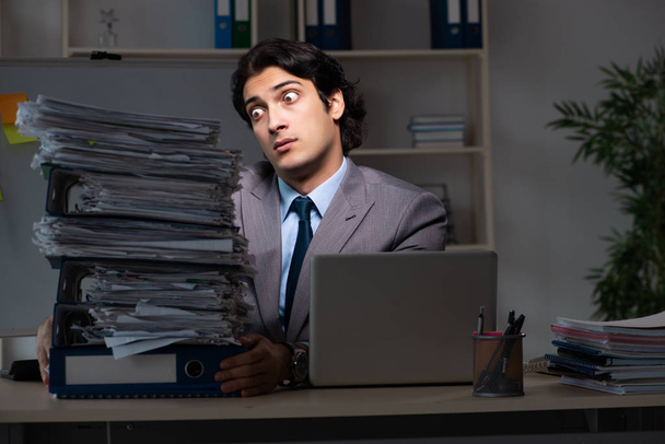 Молодий працівник чоловічої статі працює пізно в офісі
 - Фото, зображення