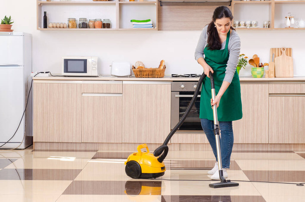 Young female contractor doing housework - 写真・画像