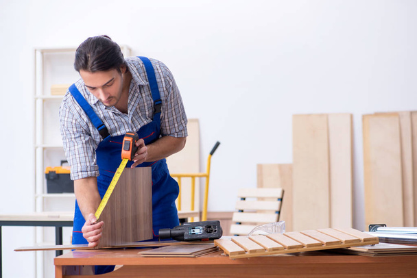 Joven carpintero masculino trabajando en interiores - Foto, imagen